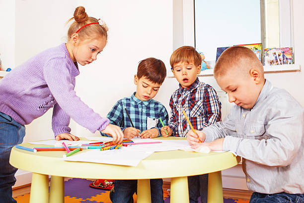 istock Group of kids drawing while standing near the table 636790298