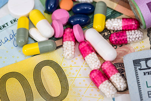 istock macro pills and tablets on euro and dollar banknotes for 636792432