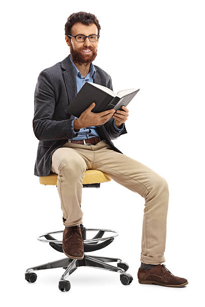 istock Bearded man sitting on a chair and holding a book 636792648
