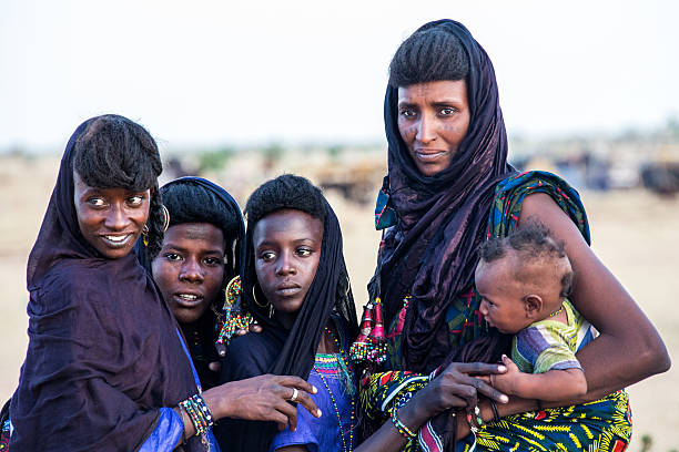 Peul nomad girls watching the Gerewol Festival Sahel Niger Tahoua, Niger - September 29, 2016: Peul nomad girls watching the young dancers during the Gerewol Festival. The Gerewol Festival is celebrated by the Peul nomads in the Sahel zone Niger. niger stock pictures, royalty-free photos & images