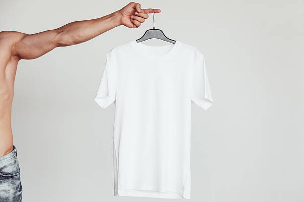 istock Guy with naked torso holding a white T-shirt in 636796538