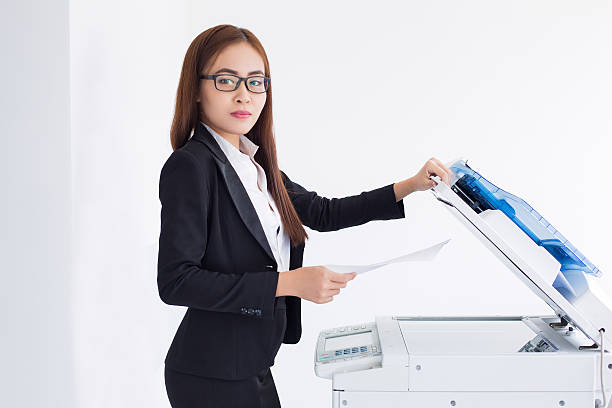 istock Content Asian Female Assistant Using Photocopier 636797232