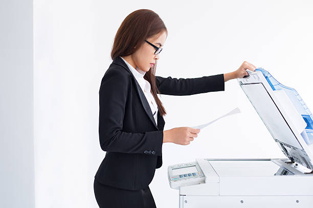 istock Young Asian Female Secretary Using Laser Copier 636798024