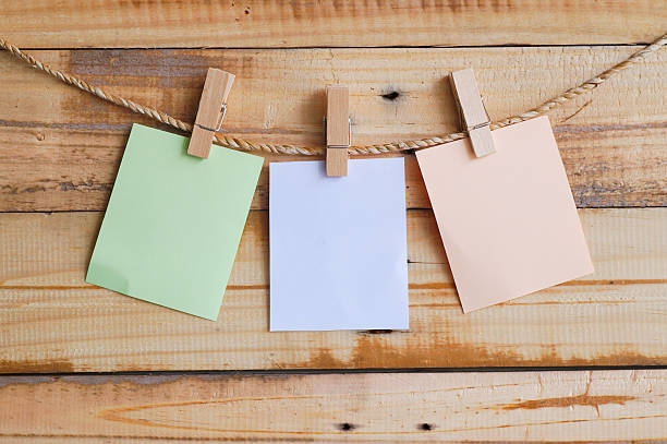 istock clothespin hanging with blank paper on wooden background 636798036
