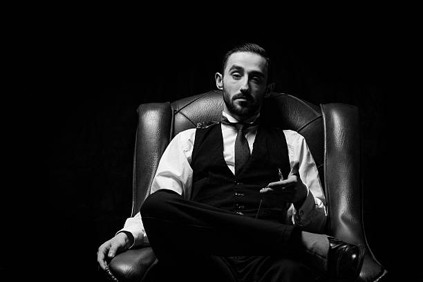 istock side view of an elegant young businessman smoking a cigarette 636798410