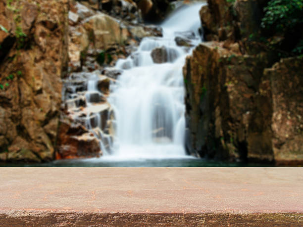 istock Wooden board empty table in front of waterfall 636800002