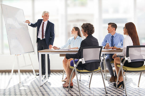 istock Positive senior leader drawing graph at meeting 636801560