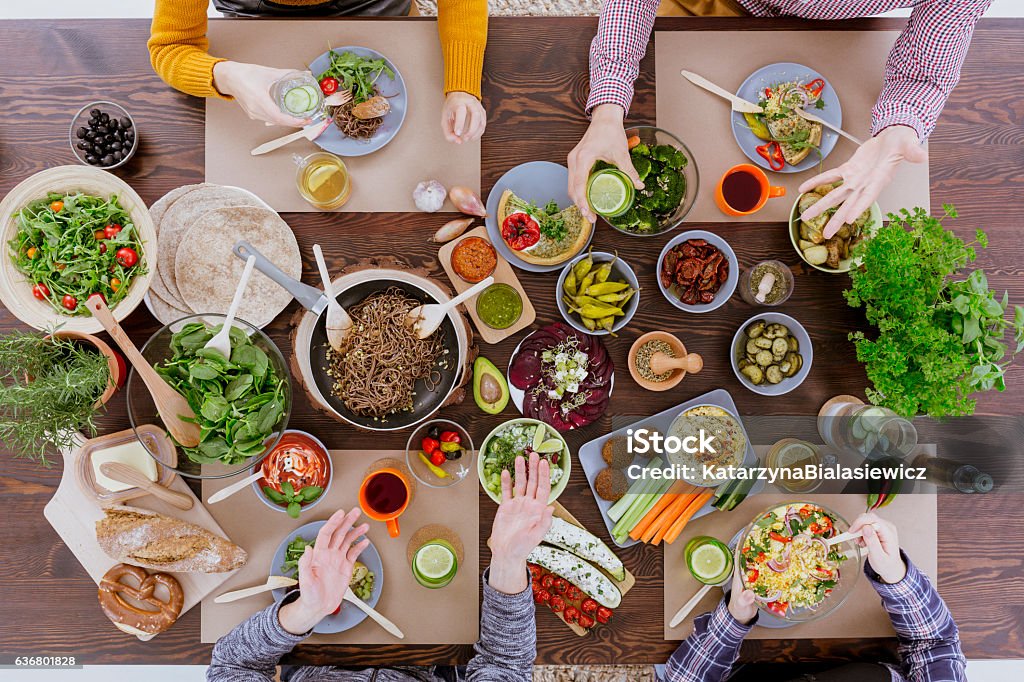 People eating and drinking People eating healthy food, drinking water, sitting beside wood table Eating Stock Photo