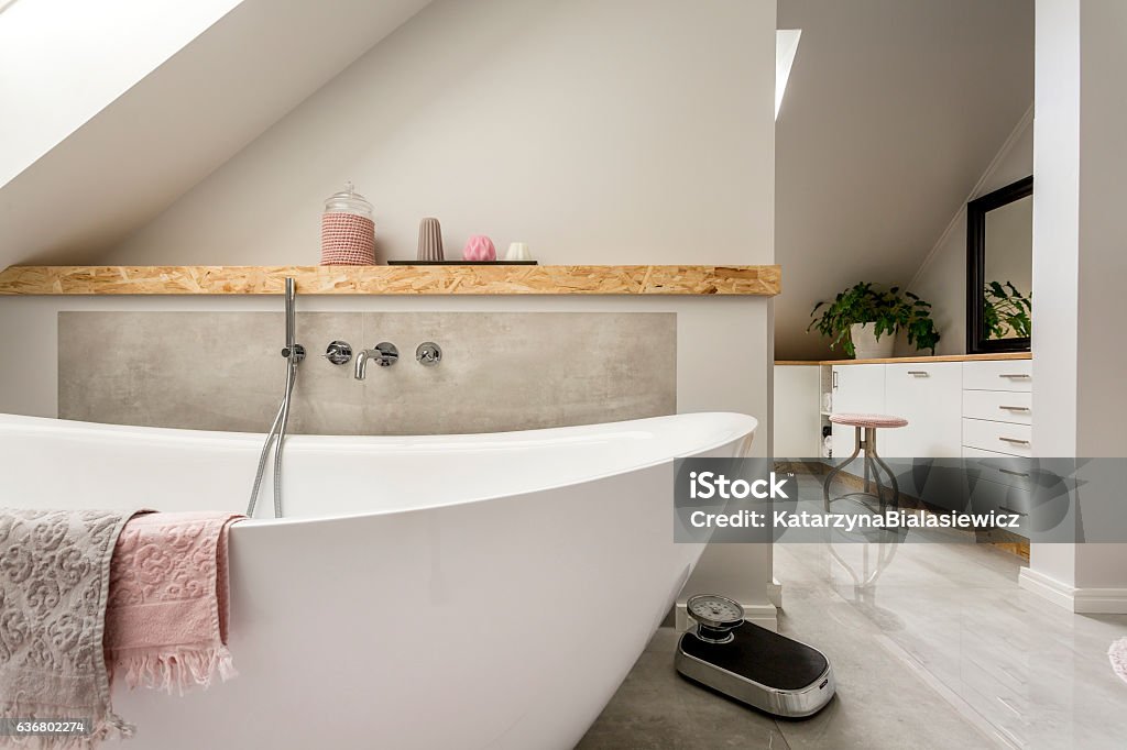Freestanding bath in grey bathroom Freestanding bath with towels in grey modern bathroom En Suite Bathroom Stock Photo