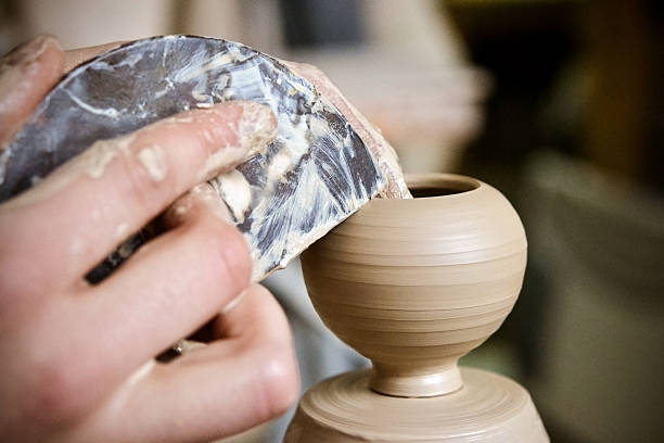 istock Potter makes a pretty small vase from clay 636803390