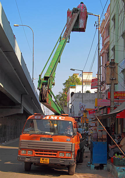 Hyderabad, India - March 11, 2015: man on elevation deck of manipulator is mounting electric lamps outdoor in Hyderabad, India