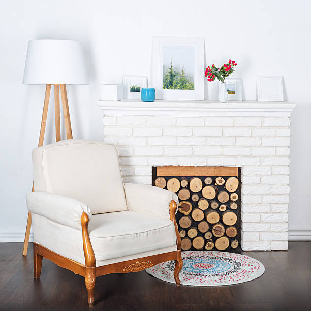 istock Modern light interior with fireplace and cozy white armchair. 636806292