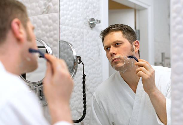 istock Handsome man shaving in bathroom. 636812204