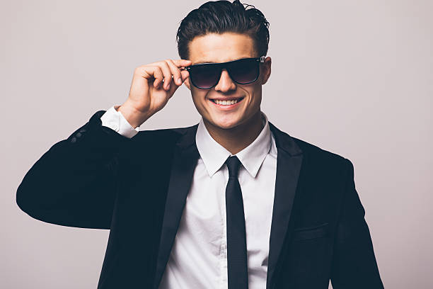 istock Young businessman In suit on grey 636818578