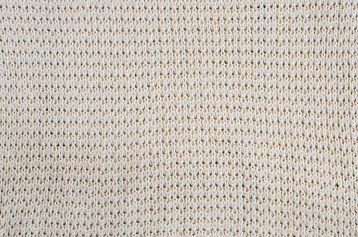 Vintage Beige Knitted Fabric Texture. Crochet Warm Woolen Yarn Background. Close-up. Selective focus.