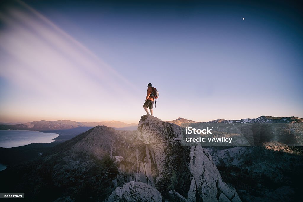Successful Summit in Lake Tahoe A mountain climber stands successful on top of a mountain summit in Lake Tahoe, California Leadership Stock Photo