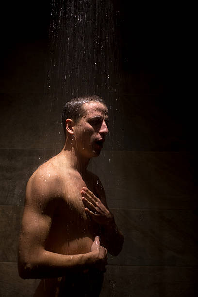 jeune homme prenant une douche avec l’eau sur lui - shower portrait male beauty chest photos et images de collection