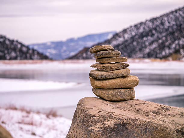 istock Isolated Rock Cairn with Frozen Lake Background 636823804