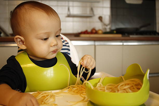 istock Baby eat pasta on highchair 636825986