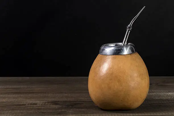yerba mate in gourd matero on wooden table. image with copy space
