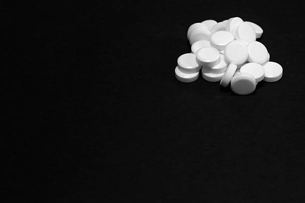 istock White pills, medicines, on a blach background 636826538