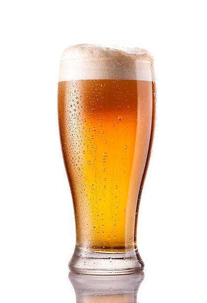 light cold beer in frosty glass isolated on white light cold beer in frosty glass isolated on a white background lager stock pictures, royalty-free photos & images