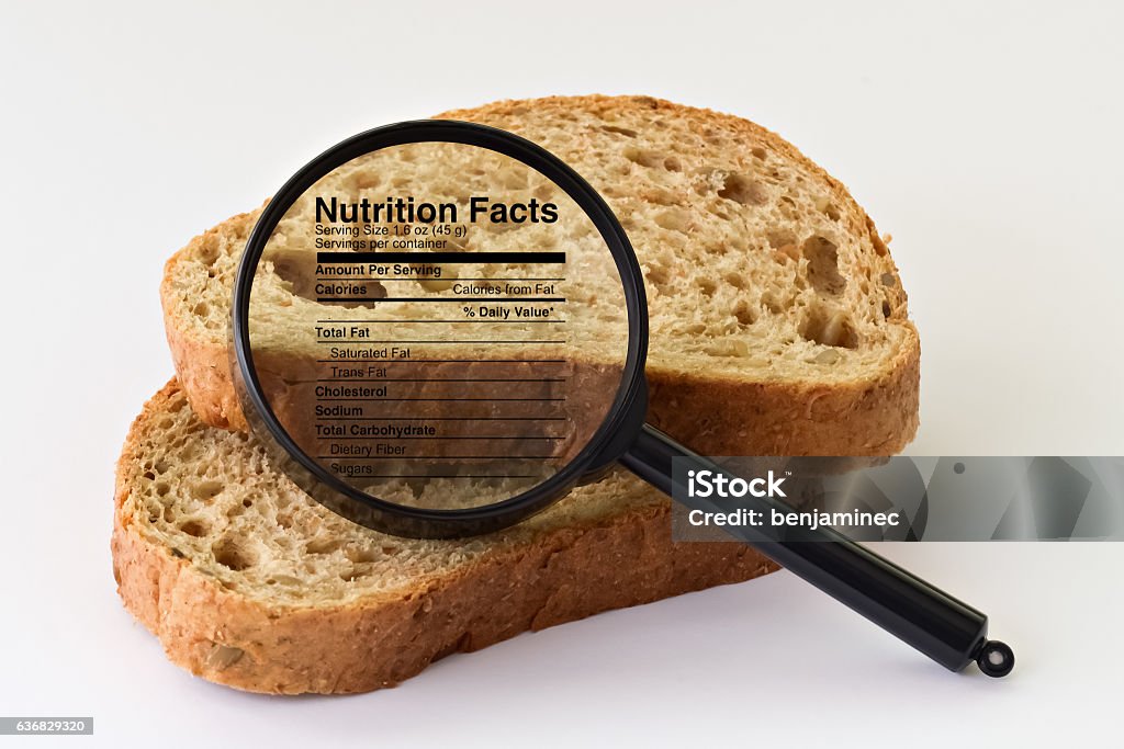 Bread under a magnifier Two slices of bread placed under a magnifier on bright background Magnifying Glass Stock Photo