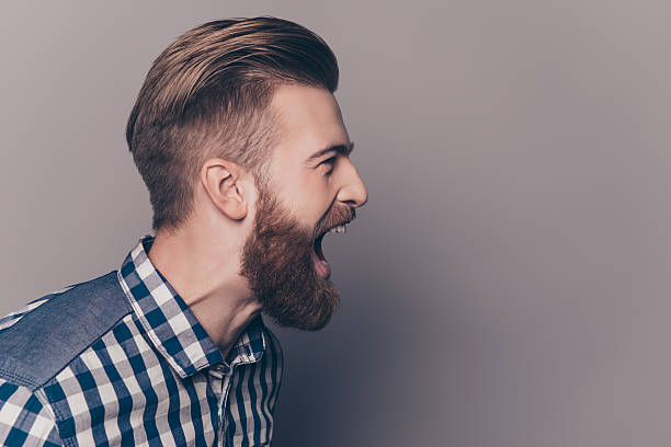 istock unhappy furious businessman open mouth and shouting 636830242