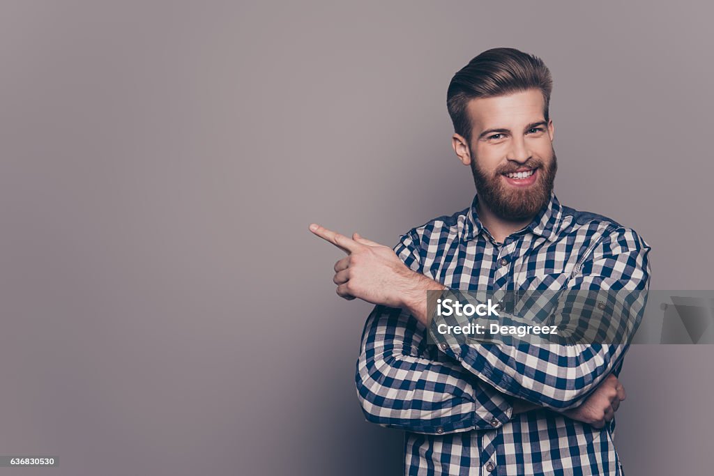 Cheerful handsome  stylish man  pointing to the side Cheerful handsome  stylish man showing direction and pointing with finger Men Stock Photo