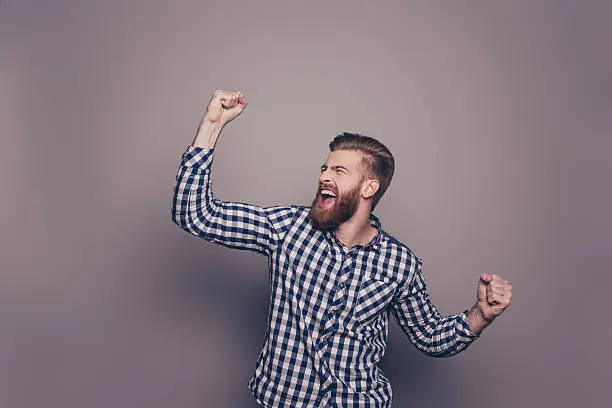 Photo of Yes, he did it!  happy bearded man raised hands