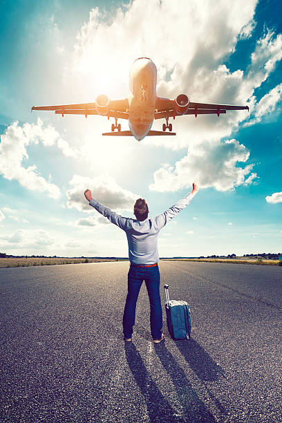istock Happy passenger cheers as airplane takes off above his head 636831440