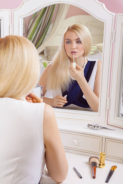 istock Beautiful woman is doing makeup in front of mirror. 636833248