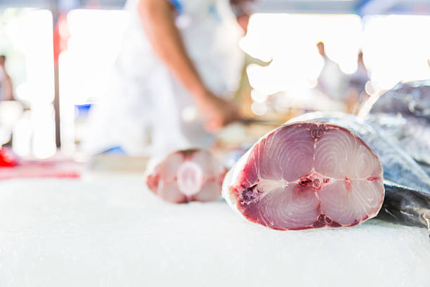 Clean cut kingfish left on the chopping block. Slab of Kingfish meat left on a chopping table to be taken to the stall to be sold. opah photos stock pictures, royalty-free photos & images