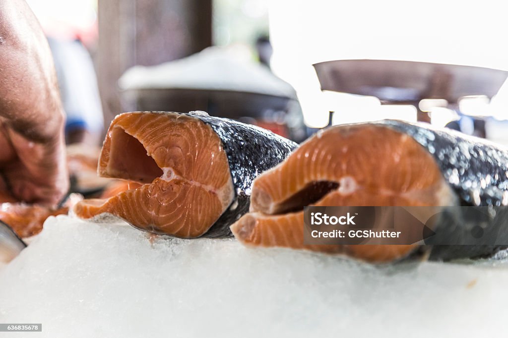 Do you like this kind of cut sir? Fishmonger showing a type of cut meat available for purchase to a customer. Abundance Stock Photo