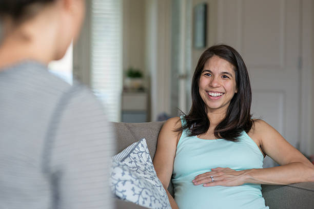 istock Ethnic pregant female smiling and laughing with her 636837378