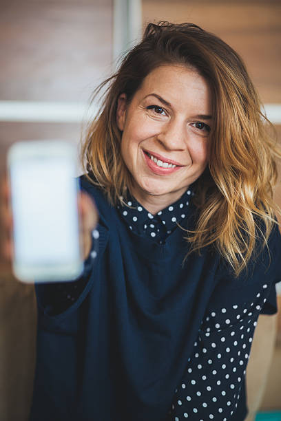 istock Smiling woman showing her phone 636837388