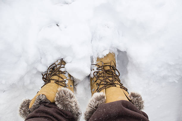 istock close up of snow boots in the snow. 636839862