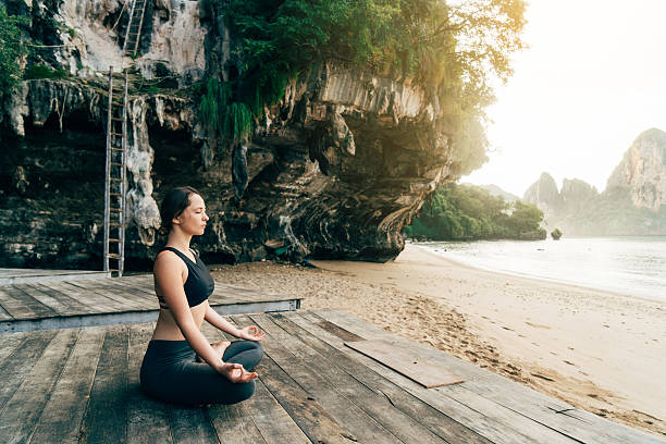 istock Woman doing yoga on the beach 636848376