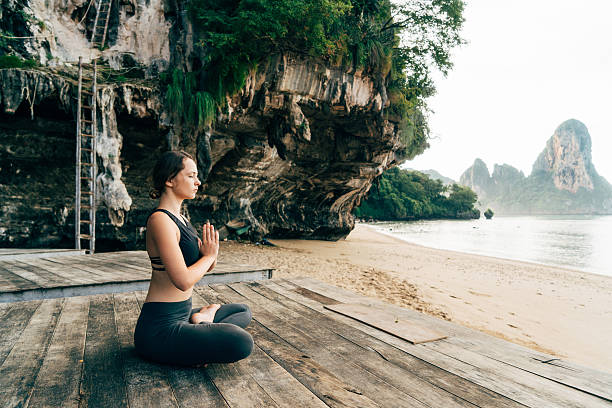 istock Woman doing yoga on the beach 636848382