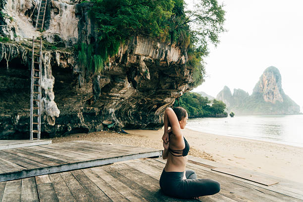 istock Woman doing yoga on the beach 636848388