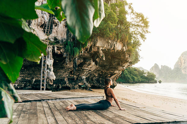 istock Woman doing yoga on the beach 636848456