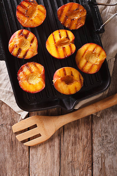 istock Summer dessert: Cooking Ripe peaches on a grill pan close-up 636851164