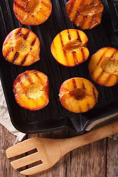 istock Ripe peaches on a grill pan close-up. Vertical top view 636851202