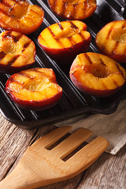 istock Summer dessert: Cooking Ripe peaches on a grill pan close-up 636851268