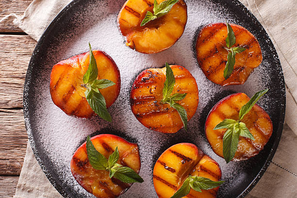 istock Grilled Peaches with powdered sugar and mint closeup 636851524