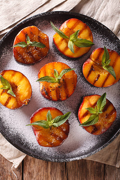 istock Grilled Peaches with powdered sugar and mint closeup 636851632