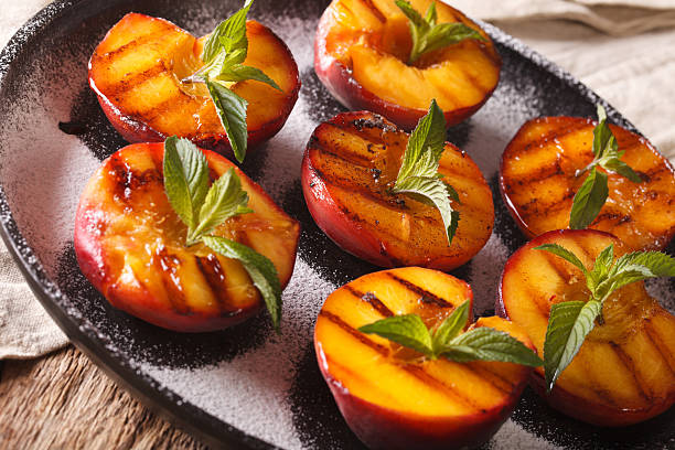 istock grilled Peaches with powdered sugar and fresh mint close up 636851718