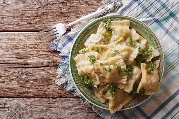 Swabian cuisine: Maultaschen dumplings stuffed with meat and spinach on a plate close-up. Horizontal view from above