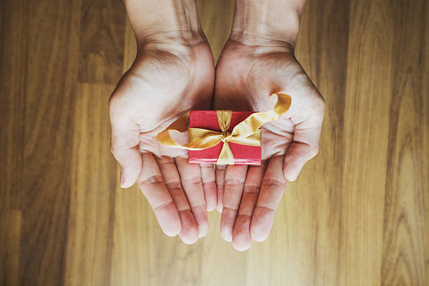 istock Asian male hand holding red gift box 636854020