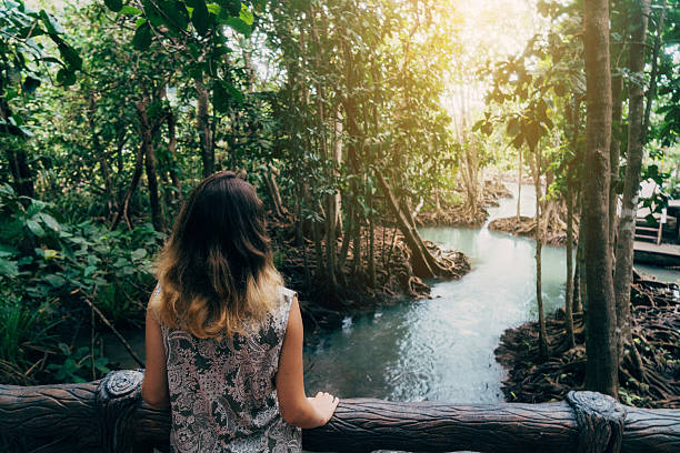istock Woman looking at the river in tropical forest 636854252